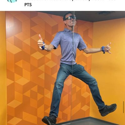 Team Blue member posing in the Museum of Illusions’ Symmetry Room during a scavenger hunt. This team building challenge encourages creativity, engagement, and interactive fun in a unique exhibit. thumbnail