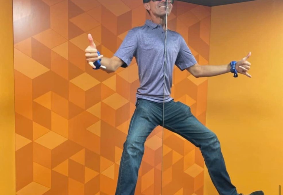 Team Blue member posing in the Museum of Illusions’ Symmetry Room during a scavenger hunt. This team building challenge encourages creativity, engagement, and interactive fun in a unique exhibit.