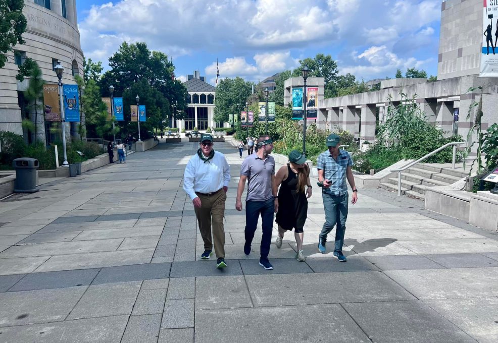 Team exploring an outdoor museum during a scavenger hunt. Participants collaborate to solve challenges, navigate clues, and engage in a fun team building experience that promotes problem-solving and teamwork.