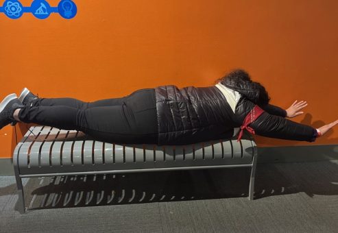 Team member participating in a fun optical illusion at the Museum of Illusions during a scavenger hunt. The interactive exhibit encourages creativity and problem-solving as they navigate the illusions with the team.