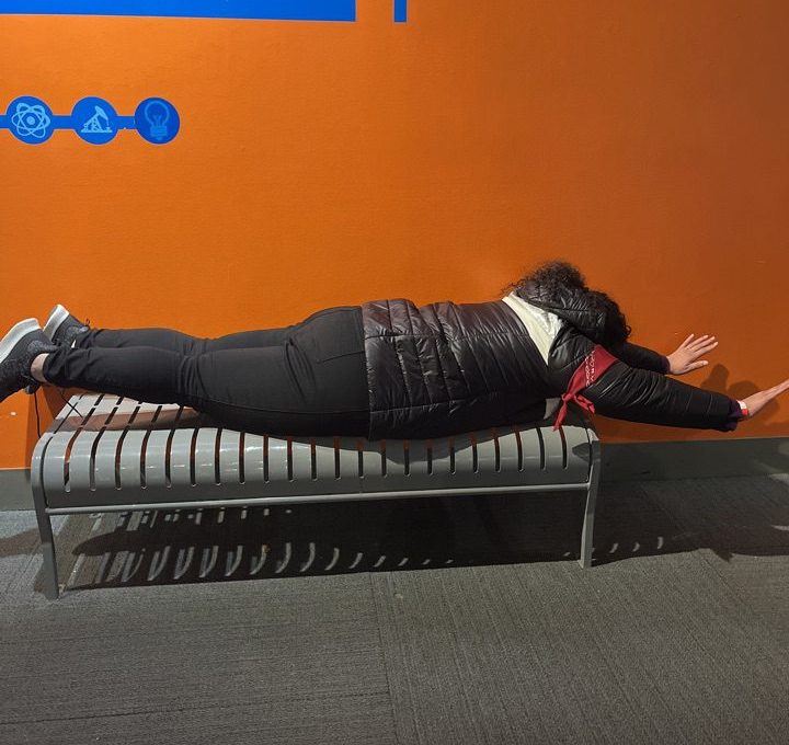 Team member participating in a fun optical illusion at the Museum of Illusions during a scavenger hunt. The interactive exhibit encourages creativity and problem-solving as they navigate the illusions with the team.