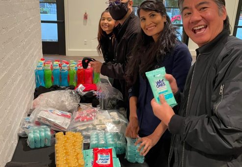 Team members organizing essential items for disaster relief care kits during the Team Disaster Relief event. They are collaboratively preparing supplies, including snacks and hygiene products, to support recovery efforts.