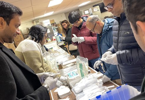 Team members assembling disaster relief care kits during the Team Disaster Relief event, carefully preparing essential supplies while working together to support those in need.