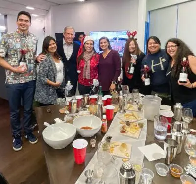 Team celebrating after a successful mixology session, holding their cocktail creations. The event fosters teamwork, creativity, and fun as participants bond over crafting drinks in a lively atmosphere. thumbnail