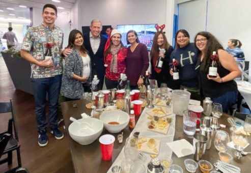 Team celebrating after a successful mixology session, holding their cocktail creations. The event fosters teamwork, creativity, and fun as participants bond over crafting drinks in a lively atmosphere.