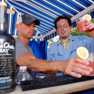Two team members toasting with freshly made cocktails at a mixology event. The hands-on class promotes teamwork and creativity as participants craft and enjoy their own drinks together. thumbnail